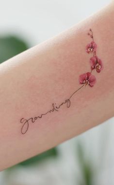 a woman's arm with flowers on it and the word joy written in cursive writing