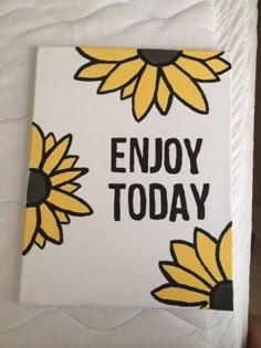 a close up of a bed with a white sheet and yellow sunflowers on it