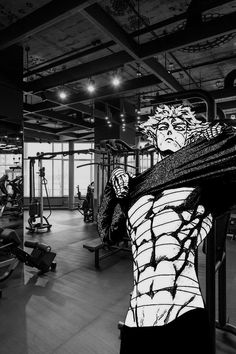 a black and white photo of a man in a gym with his back turned to the camera