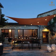 an outdoor dining area is lit up with string lights