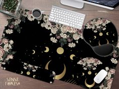 a computer mouse pad with flowers and crescents on it, next to a keyboard