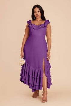 a woman wearing a purple dress with ruffles on the side and one leg