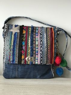 a multicolored striped purse with tassels and pom - poms