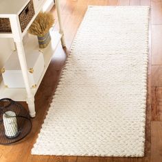 a white rug on top of a wooden floor