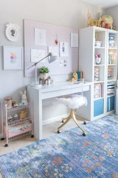 a room with a rug, desk and shelves on the wall next to each other