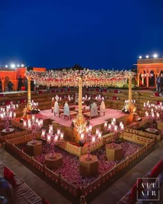 an elaborately decorated stage is lit up at night with people standing in the background