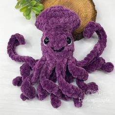 an octopus stuffed animal sitting next to a piece of wood