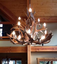 a deer antler chandelier hangs from the ceiling