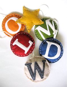 four different colored badges with the letter d on them, and one has a star