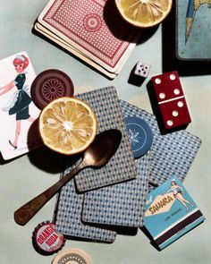 a table topped with cards, dices and lemon slices on top of each other