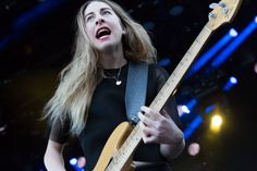 a woman with blonde hair playing an electric guitar