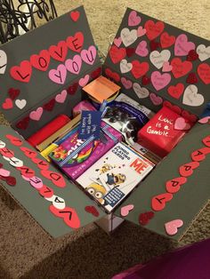 a cardboard box filled with lots of valentine's day items on top of a carpeted floor