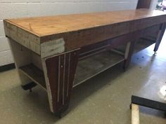 an old wooden table with wheels on it