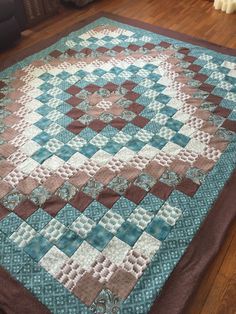 a large blue and brown quilt on the floor