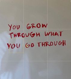 a white tile wall with red writing on it that says, you grow through what you go through