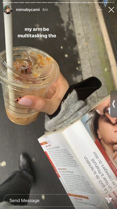 a person holding an open book and a drink in their hand with the caption my arm be multitasking tho