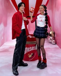 two people standing next to each other holding candy