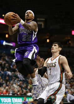 the basketball player is trying to dunk the ball in front of the other player