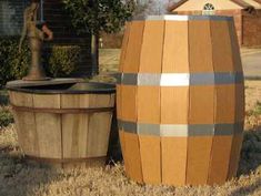 a large wooden barrel sitting next to a water faucet on top of a grass covered field