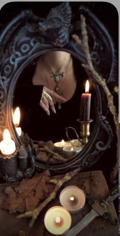 a woman's reflection in a mirror with candles