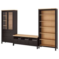 a wooden bookcase next to a black cabinet with glass doors and drawers on both sides