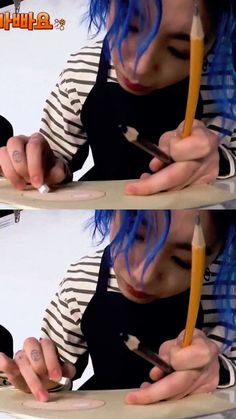 a woman with blue hair is holding a pencil