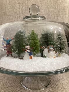 a snow globe with people and trees in it