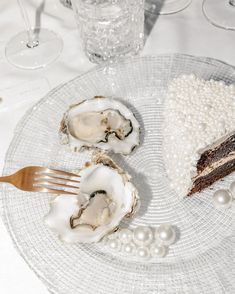 there is a piece of cake and two oysters on the plate