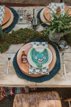 the table is set with plates and place settings for an animal themed dinner or party