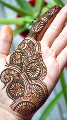 the hand is decorated with henna on it's palm and has an intricate design