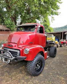 an old red truck parked in front of a house