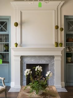 a living room filled with furniture and a fire place under a chandelier above a fireplace