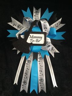 a blue and white ribbon with music notes on it that says mommy to - be