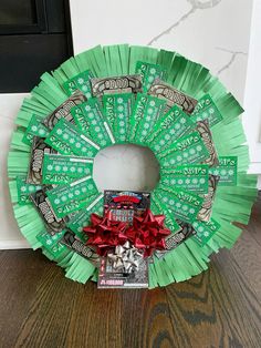 a wreath made out of green paper and candy bar wrappers