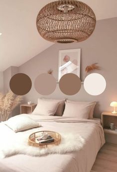 a bedroom with white bedding and neutral colored circles on the wall over the bed