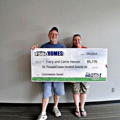 two people standing next to each other holding up a large check for $ 1, 700