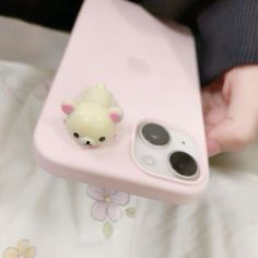 a person holding an iphone case with a small toy animal on it's side