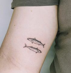 two fish tattoo on the left arm