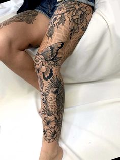 a woman laying on top of a bed covered in lots of tattooed leg covers and tattoos