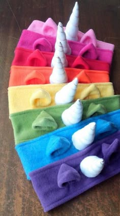 a pile of colorful towels with sea shells on them and a unicorn's horn sticking out of the middle