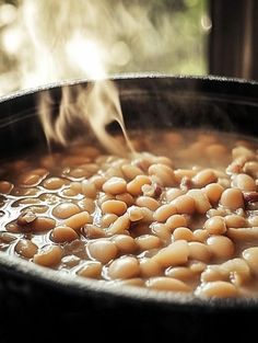 a pot filled with beans cooking on top of a stove