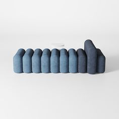 a row of blue pillows sitting next to each other on top of a white surface