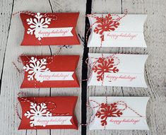 four red and white tags with snowflakes on them sitting next to each other