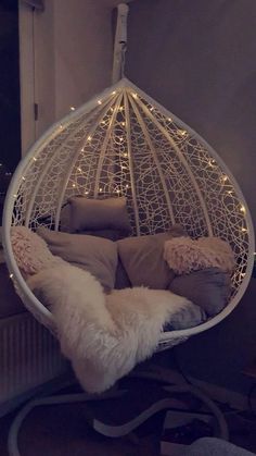 a white hanging chair with lights on it