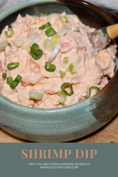 a bowl full of shrimp dip with green onions and celery