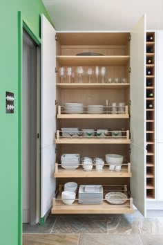 the shelves in this kitchen are full of plates and bowls, with glasses on them