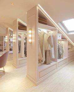 a room filled with lots of white closets next to a window covered in lights