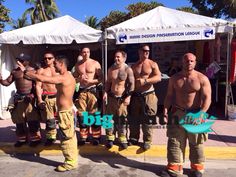 several firemen standing in front of a tent with their shirts off and no shirt on