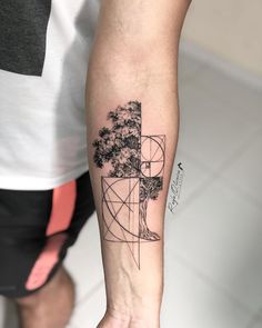 a man's arm with a tree and geometric shapes on it, in front of a white tile floor