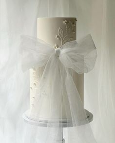 a white wedding cake with a bow on top